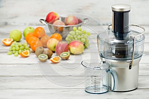 Modern electric juicer and various fruit on kitchen counter, healthy lifestyle