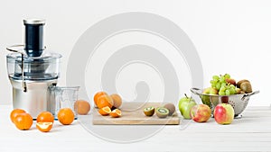 Modern electric juicer and various fruit on kitchen counter, healthy lifestyle photo
