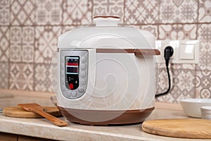 Modern Electric Multi Cooker on a table in kitchen in working order. Copy space