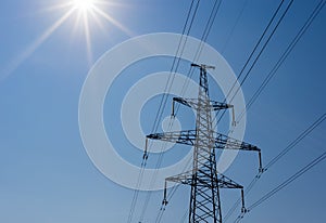 Modern electricity pylon and the suns rays - space for text.
