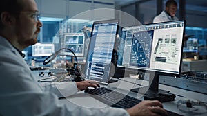 Modern Electronics Facility: Scientist, Engineer Works on Computer with CAD Software. Does Design