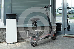 Modern electroscooter standing near entrance to office building photo