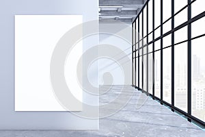 Modern empty concrete office premises interior with panoramic windows, city view, shadows and blank white mock up banner on wall.