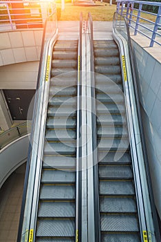 Modern empty escalator stairs down to underground building