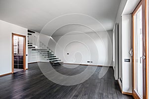 Modern empty interior with dark parquet and staircase