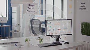 Modern empty office interior with plastic separators and keep social distance poster