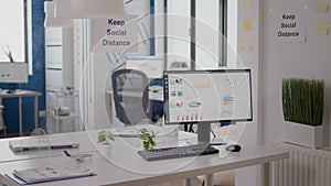 Modern empty office interior with plastic separators and keep social distance poster