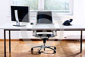 Modern empty office space desk with computer, phone and chair. photo