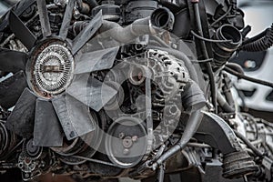 Modern engine removed from the car with ancilares visible, fan, belt, alternator.