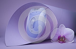 Modern epilator on purple background. skin care, removal of unwanted hair.
