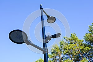 Modern equipment for park infrastructure, led lamps and a surveillance system camera on a metal pole