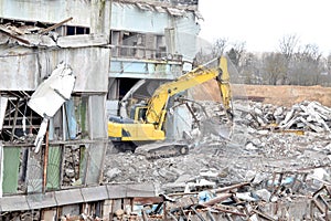 Modern excavator clears the debris of a building after an earthquake