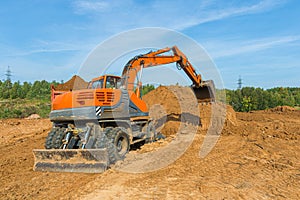 The modern excavator performs excavation work on the construction site