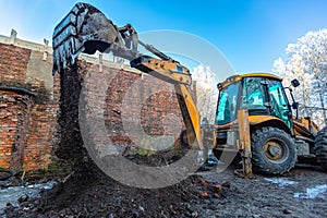 The modern excavator performs excavation work on the construction site. Front view of a digger bucket of digging ground