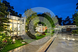 Modern exterior of luxury private house at twilight. Beautiful garden.