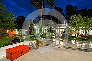 Modern exterior of luxury private house at twilight. Beautiful garden.