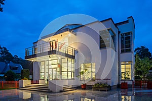 Modern exterior of luxury private house at twilight. View of entrance.