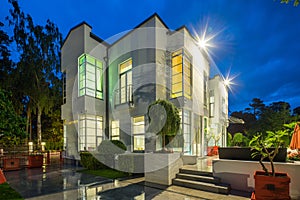 Modern exterior of luxury private house at twilight. View of entrance.