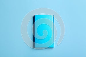 Modern external portable charger on blue background, top view