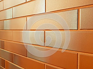 Modern facade wall made of orange ceramic tiles. Horizontal perspective receding into the distance.
