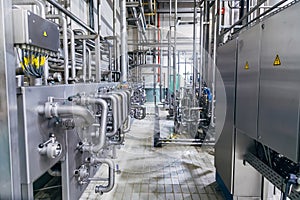 Modern factory interior. Stainless steel pipeline with valve and, manometers, switch boxes