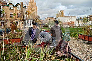 A modern family parents and children, is working together to beautify their front yard with flowers in preparation for