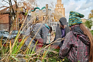 A modern family parents and children, is working together to beautify their front yard with flowers in preparation for