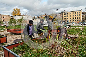 A modern family parents and children, is working together to beautify their front yard with flowers in preparation for