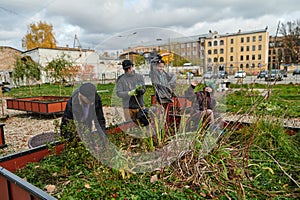 A modern family parents and children, is working together to beautify their front yard with flowers in preparation for