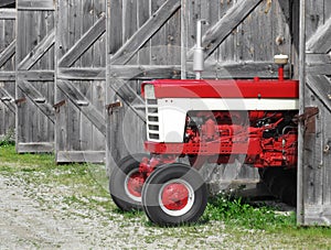 Modern farm tractor in an old shed