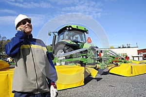 Modern farmer with tractor and ploughs