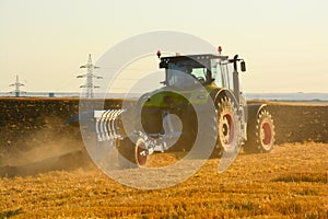 Modern farming with tractor in plowed field photo