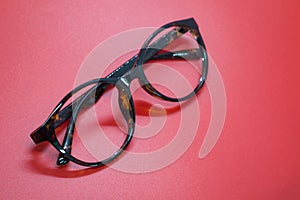 Modern fashionable spectacles on red background.