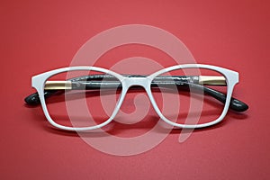 Modern fashionable spectacles on red background.