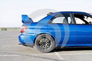 a modern fast race sport blue car on the track on summer practice day