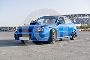 a modern fast race sport blue car on the track on summer practice day