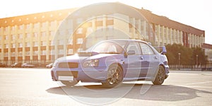 a modern fast race sport blue car on the track on summer practice day