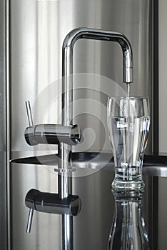 Modern faucet and glass of water