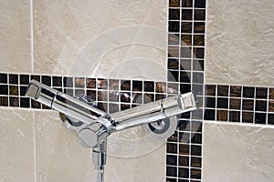 Modern faucet on a tiled wall