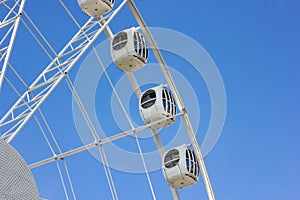 The modern Ferris wheel against the blue sky
