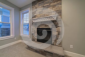 Modern fireplace and decorative shelf against stone brick accent wall of home