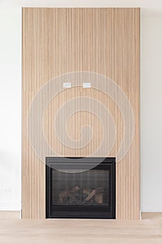 A modern fireplace with white oak wood slats.