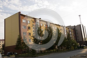 Modern five-storeyed house with flats. It was colored in red, orange and white colors