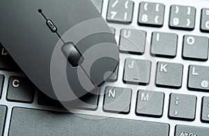 Modern flat office PC mouse laying on a computer keyboard, two objects closeup, nobody, detail. IT job tools, work place symbol