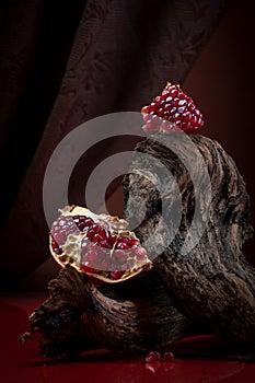 Modern food photography in theatrical entourage - ripe pomegranate. Shooting in a discreet style