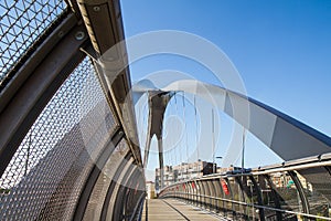 Modern footbridge with supporting arches and steel bulkheads photo