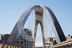 Modern footbridge with supporting arches and steel bulkheads photo