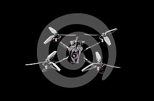 Modern FPV drone on a black background. Four-engine aircraft on the radio control. Drone for racing, filming and entertainment