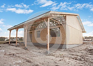 Modern frame energy efficient house under construction with membrane coverings, roof shingles and insulation materials. photo