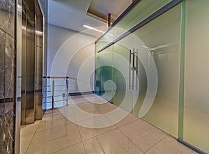 Modern frosted glass doors entrance near elevator